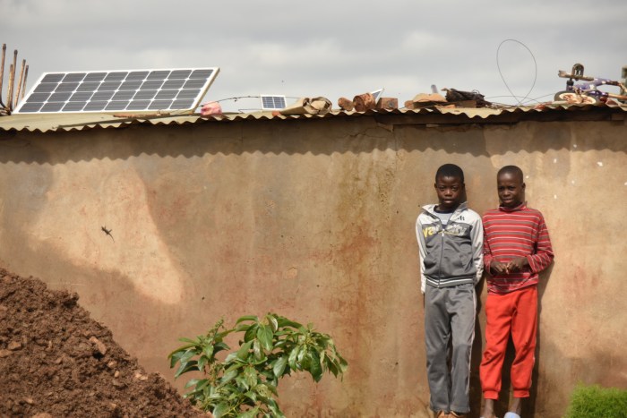 These two boys were hanging out when I walked by, and quickly chose a formal pose in front of their home, which has a large permanent solar panel mounted on the roof.